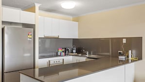 A modern kitchen with stainless steel appliances, white cabinetry, and a granite countertop. - Quiet Family Stay in Albion | Parking & City Views (Albion)