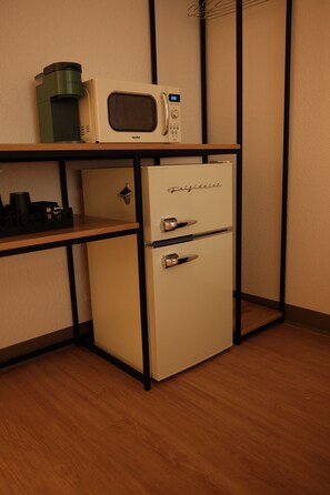 A kitchenette with a microwave, coffee maker, and a mini-fridge.