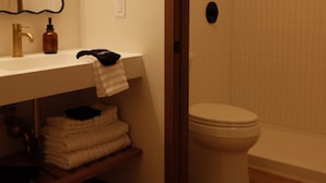 Een badkamer met een wastafel, spiegel en douche.