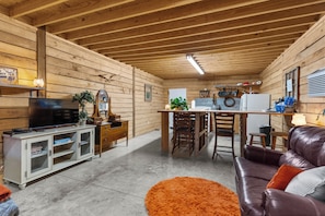 A compact living space with a kitchen area, a television, a sofa, and a dining table.