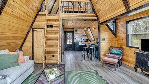 En inredning i loftstil med ett kök, en matplats och en sittgrupp.