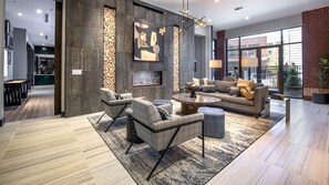 Una sala de estar moderna con chimenea, zona de estar y ventanas amplias.