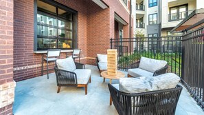 Eine Terrasse mit Sitzgelegenheiten, einem Tisch und einer hohen Holzkonstruktion.