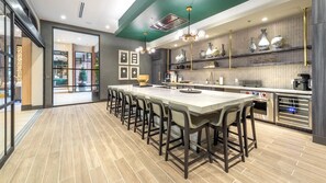 Una cocina moderna con una isla central, taburetes de bar y un horno empotrado.
