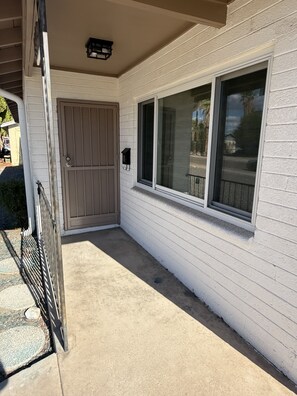 A house with a gated entrance, a covered porch, and a window with a view of the street. - Casa on 18th-Spacious 3 Bed/2Bath - Central Tucson (Tucson)