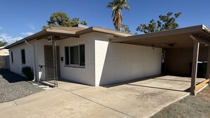 Een gelijkvloers huis met garage, een overdekte veranda en een kleine voortuin.