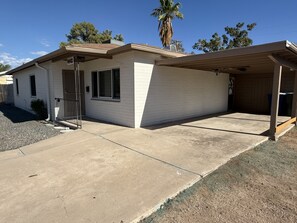 A single-story house with a garage, a covered porch, and a small front yard. - Casa on 18th-Spacious 3 Bed/2Bath - Central Tucson (Tucson)