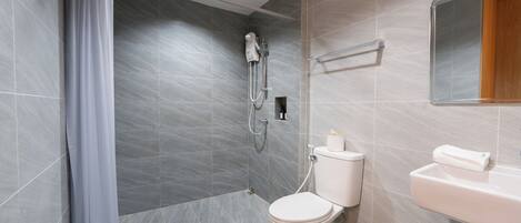 A modern bathroom with a shower, toilet, and sink.