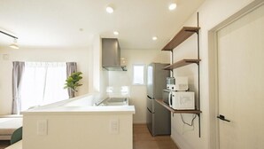 A modern kitchen with a central island, built-in appliances, and a minimalist design. - Furano Ezo Murasaki B (Furano)