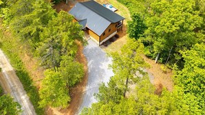 Eine Hütte mit schrägem Dach, umgeben von dichtem Wald.