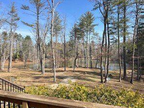 A campground with a wooden deck, surrounded by trees and a lake. - Lakeside Cabin minutes to Asheville (Buncombe County)