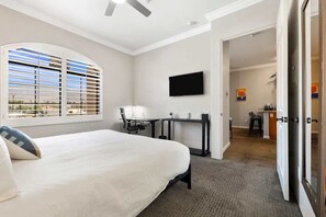 Ein Hotelzimmer mit Bett, Schreibtisch, Stuhl, Fernseher und Blick aus dem Fenster.