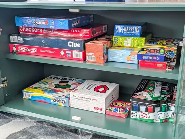 Un estante con varios juegos de mesa y rompecabezas.