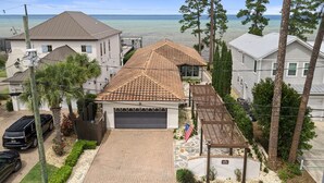 A residential property with a garage, a covered patio, and a view of the sea. - Private Dock Waterfront Home in Miramar (Miramar Beach)
