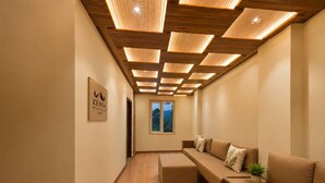 Un interior moderno con techo de madera, un conjunto de sofás y un cuadro en la pared.