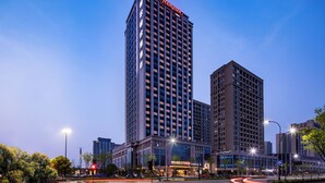 A high-rise hotel with a prominent 'Hampton' sign, multiple floors, and a modern architectural design. - Hampton by Hilton Hangzhou Xiaoshan People's Square (Hangzhou)