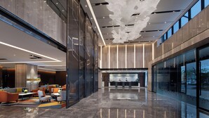 A modern lobby with a reception desk, seating area, and large windows. - Hampton by Hilton Hangzhou Xiaoshan People's Square (Hangzhou)
