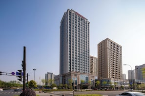 Ein Hochhaus mit modernem architektonischen Design, das eine markante Eingangshalle und mehrere Stockwerke aufweist.