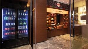 A hotel lobby with a reception desk, a wall-mounted welcome sign, and a wine display. - Hampton by Hilton Hangzhou Xiaoshan People's Square (Hangzhou)