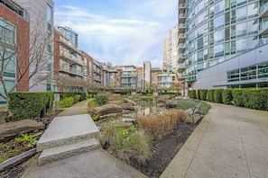 A courtyard with a water feature, stone steps, and neatly trimmed hedges. - Cozy 2 Bedroom 2 Bathroom Downtown Vancouver/Pool/Hot Tub/Free Parking (Vancouver)