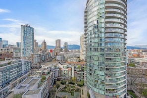 A high-rise building with multiple balconies, surrounded by other modern buildings and a clear sky. - Cozy 2 Bedroom 2 Bathroom Downtown Vancouver/Pool/Hot Tub/Free Parking (Vancouver)