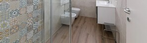 Un baño con ducha, inodoro y lavamanos.