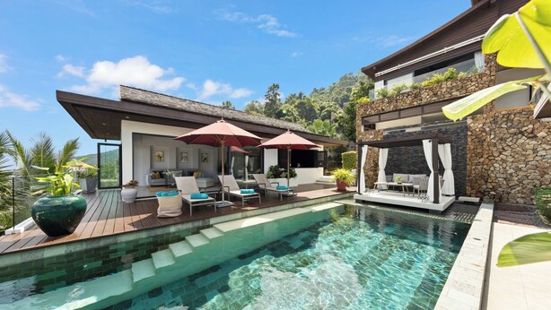 Ein moderner Poolbereich mit Liegestühlen, einer Pergola und einer Steinmauer.