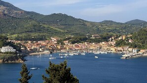 A coastal town with a marina, buildings, and hilly terrain. - Residenza Verde Blu - Verde Blu Primo Piano (620) (Capoliveri)