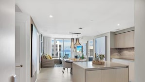 Une cuisine moderne dotée d’un îlot central, de luminaires suspendus et offrant une vue sur la ville.