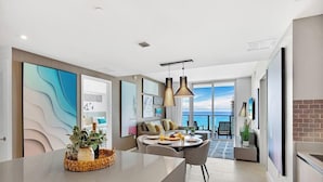 Un intérieur moderne comprenant un coin repas, un canapé et une vue sur la mer.