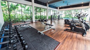 A gym with exercise equipment, large windows, and a view of greenery. - Midhills Genting by Manhattan (Genting Highlands)