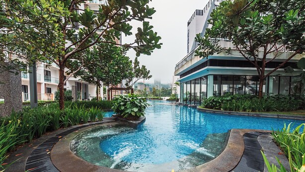 A swimming pool surrounded by greenery and modern buildings. - Midhills Genting by Manhattan (Genting Highlands)
