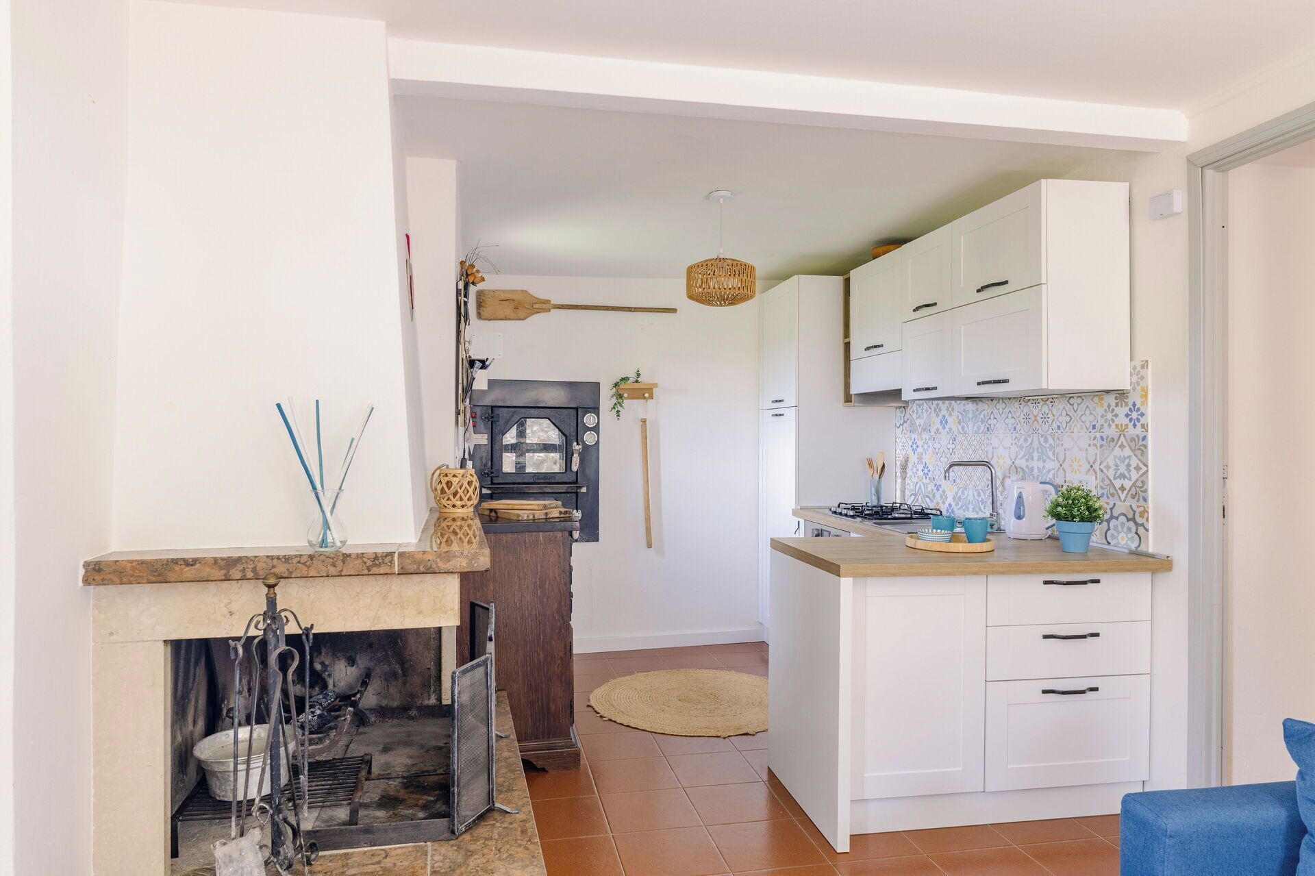 Una cocina compacta con armarios blancos, una estufa integrada y un pequeño comedor.