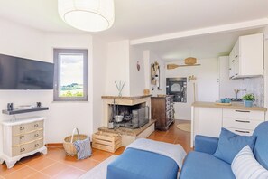 Ein Wohnzimmer mit Fernseher, Sofa und Kamin.