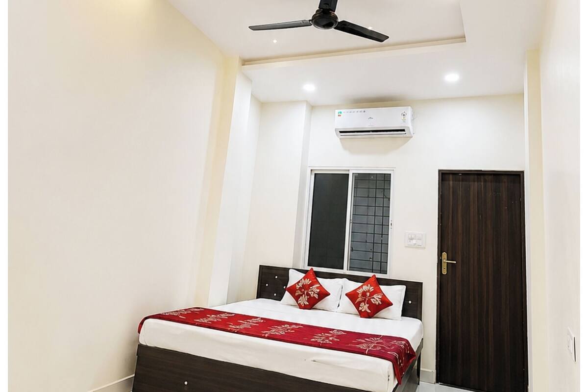 Ein Schlafzimmer mit Bett, Klimaanlage, Deckenventilator und einer Tür.