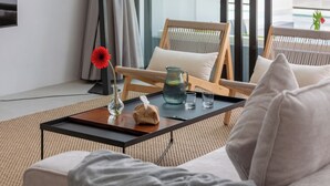 A modern living room with a sofa, a coffee table, and a chair. - Elegant Pool Access Townhouse Near Beach (Bophut)