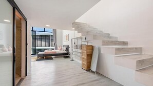 A modern interior with a staircase, a bed, and a large window. - Elegant Pool Access Townhouse Near Beach (Bophut)