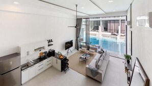A modern apartment with a kitchen, living area, and a balcony with a pool. - Elegant Pool Access Townhouse Near Beach (Bophut)