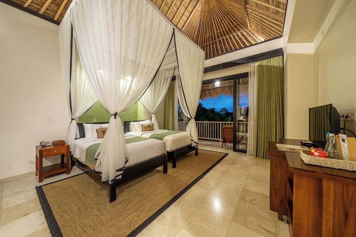 A bedroom with a bed, a desk, and a balcony.