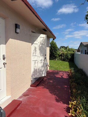 A house with a white door, a red pathway, and a green lawn. - 2-bedroom apartment in wonderful Hollywood with AC and comfort. (Hollywood)