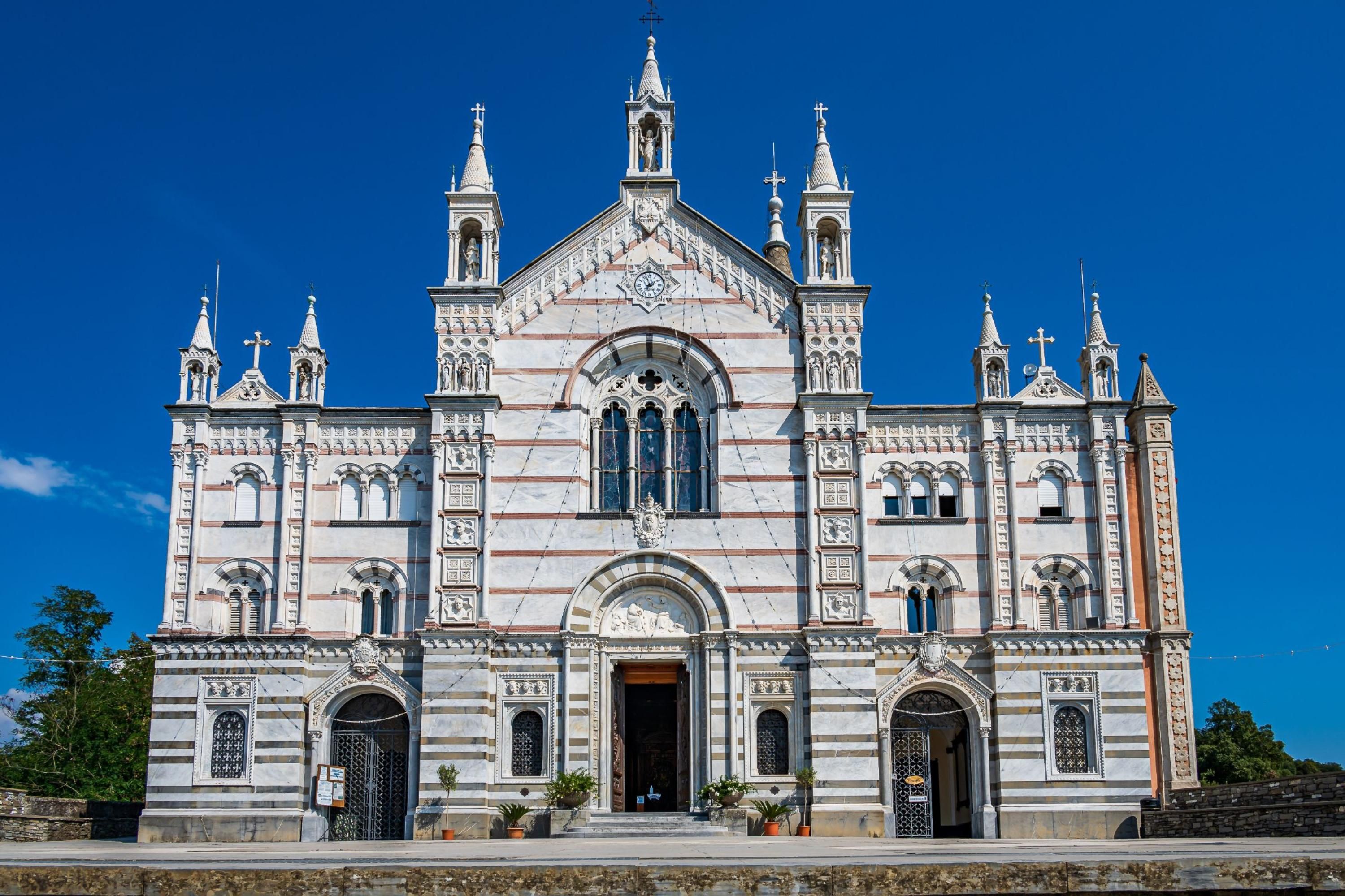 Uma igreja grande e ornamentada, com um arco central imponente e diversas torres.