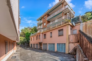 Una calle estrecha flanqueada por edificios, con balcones y antenas parabólicas.