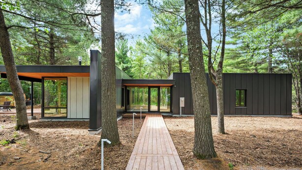 A modern cabin with a wooden deck, surrounded by trees. - 3 Luxury Cabins on 40 wooded acres @ Oak & Ember Luxury Resort (Wisconsin Dells)