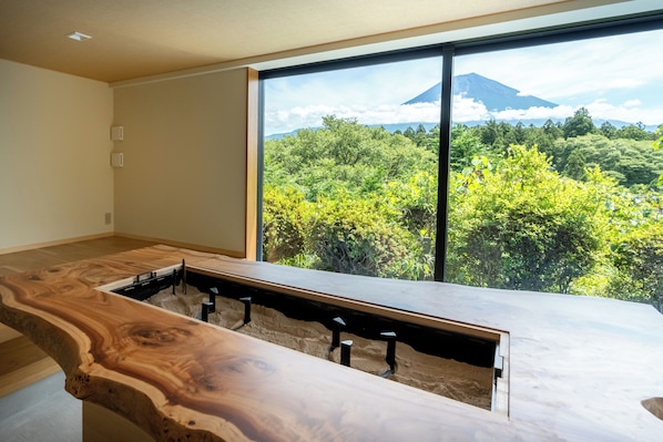 A modern room with a large window, a wooden table, and a view of a mountain. - nakafuji (Fujinomiya)