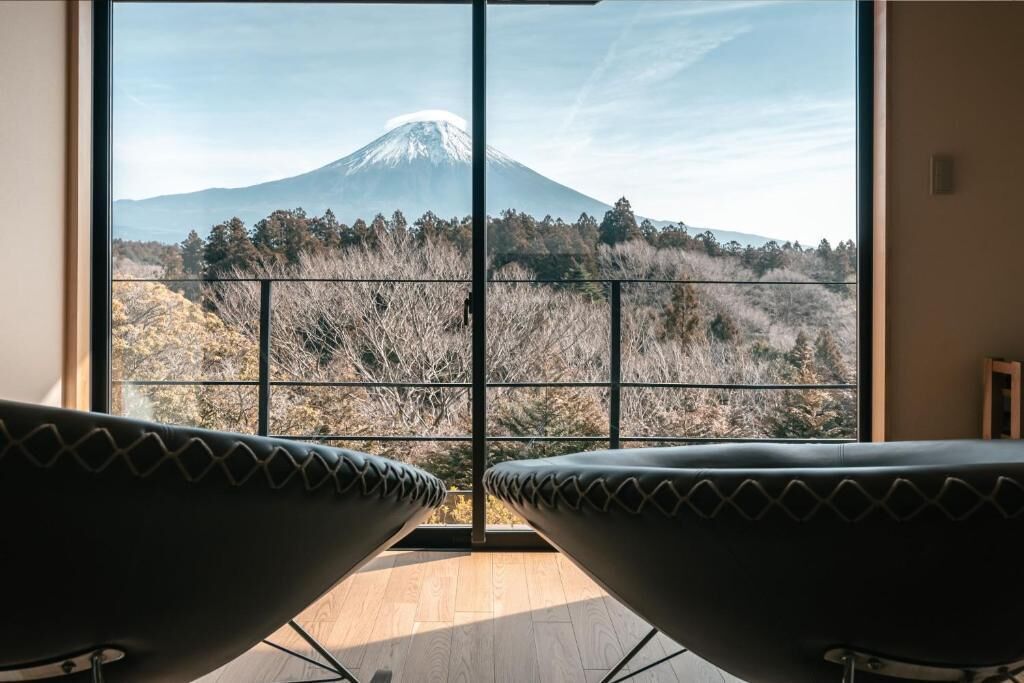 A room with a large window offering a view of a mountain.