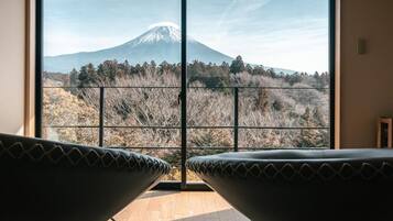 A room with a large window offering a view of a mountain.