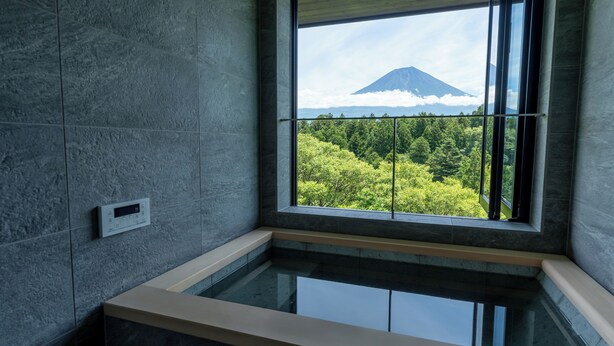A modern bathroom with a built-in bathtub, a window with a view of a mountain and forest. - nakafuji (Fujinomiya)