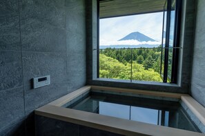 A modern bathroom with a built-in bathtub, a window with a view of a mountain and forest. - nakafuji (Fujinomiya)