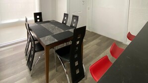 Un comedor con una mesa, sillas, una ventana y una puerta.