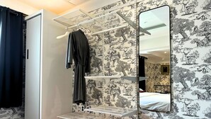 Een kamer met een stapelbed, een garderobe, een spiegel en een wand met natuurbehang.